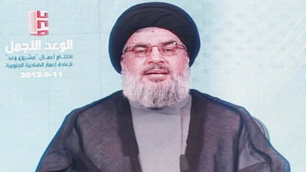 Lebanon's Hezbollah leader Sayyed Hassan Nasrallah addresses his supporters via a screen during a ceremony in Beirut's southern suburbs