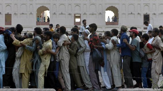 Pakistani Muslims gather for iftar food before breaking their fast during the Muslim fasting month of Ramadan in Lahore on June 21, 2015. Islam's holy month of Ramadan is celebrated by Muslims worldwide and implies fasting, abstaining from foods, sex and smoking from dawn to dusk. AFP PHOTO / Arif ALI        (Photo credit should read Arif Ali/AFP/Getty Images)