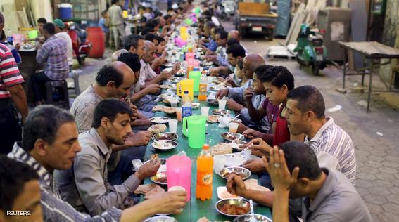 People eat their Iftar meal as they break their fast at charity tables that offer free food during the holy fasting month of Ramadan in Cairo, Egypt, June 23, 2015. REUTERS/Asmaa Waguih