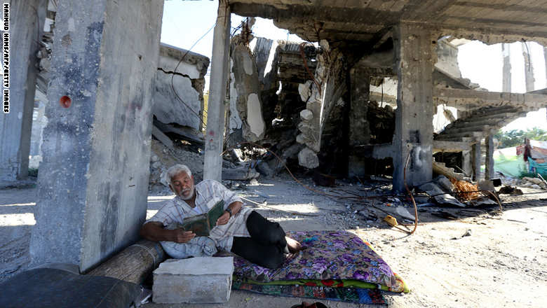 A Palestinian man reads the Koran, Islam's holy book, during the Muslim holy fasting month of Ramadan, in his house destroyed during 50-day war between Israel and Hamas-militants in the summer of 2014, in Gaza City on June 22, 2015. A widely anticipated United Nations report said both Israel and Palestinian militants may have committed war crimes during last year's Gaza war, decrying "unprecedented" devastation and human suffering. AFP PHOTO / MAHMUD HAMS        (Photo credit should read MAHMUD HAMS/AFP/Getty Images)