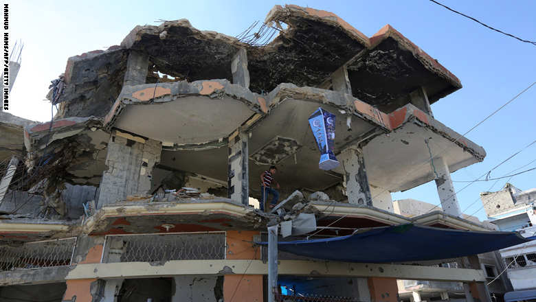 A Palestinian boy stands on June 22, 2015 near a lantern traditional hung during the Muslim holy fasting month of Ramadan, at his house in Gaza City which was destroyed during 50-day war between Israel and Hamas-militants in the summer of 2014. A widely anticipated United Nations report said both Israel and Palestinian militants may have committed war crimes during last year's Gaza war, decrying "unprecedented" devastation and human suffering. AFP PHOTO / MAHMUD HAMS        (Photo credit should read MAHMUD HAMS/AFP/Getty Images)