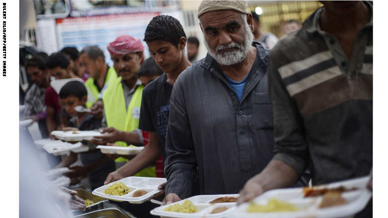 Syrians break their fasting on June 20, 2015 in Akcakale, in Sanliurfa province, during the holy month of Ramadan. The UN's refugee agency marked World Refugee Day on June 20 in Damascus, calling on the global community not to ignore the plight of millions of people around the world displaced by war and persecution. UNHCR says close to four million have fled the country as refugees, mainly to neighbouring countries that struggle to cope with the influx. AFP PHOTO / BULENT KILIC        (Photo credit should read BULENT KILIC/AFP/Getty Images)