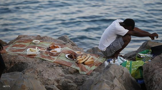 A migrant waits to break his fast with the "iftar" meal during the Muslim fasting month of Ramadan in the city of Ventimiglia on the French-Italian border on June 24, 2015. Italy warned today that EU solidarity is at stake if the 28-nation bloc fails to reach a deal on sharing the burden of the Mediterranean migrant crisis.  AFP PHOTO / VALERY HACHE        (Photo credit should read VALERY HACHE/AFP/Getty Images)