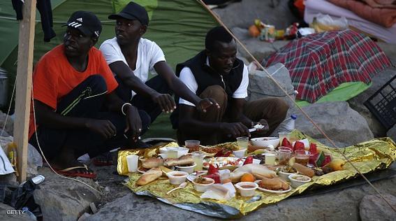 Migrants break their fast with the "iftar" meal during the Muslim fasting month of Ramadan in the city of Ventimiglia on the French-Italian border on June 24, 2015. Italy warned today that EU solidarity is at stake if the 28-nation bloc fails to reach a deal on sharing the burden of the Mediterranean migrant crisis.  AFP PHOTO / VALERY HACHE        (Photo credit should read VALERY HACHE/AFP/Getty Images)