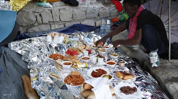 A migrant waits to break his fast with the "iftar" meal during the Muslim fasting month of Ramadan in the city of Ventimiglia on the French-Italian border on June 24, 2015. Italy warned today that EU solidarity is at stake if the 28-nation bloc fails to reach a deal on sharing the burden of the Mediterranean migrant crisis.  AFP PHOTO / VALERY HACHE        (Photo credit should read VALERY HACHE/AFP/Getty Images)