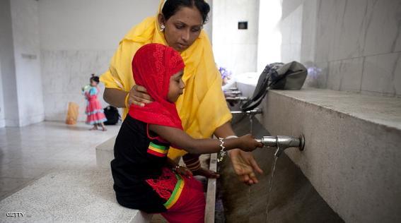 DHAKA, BANGLADESH - JULY 29: A woman and her child wash before praying at the National Mosque, Baitul Mukarram, during Eid al-Fitr on July 29, 2014 in Dhaka, Bangladesh. Muslims around the world are celebrating Eid al-Fitr, which marks the end of the holy month of Ramadan. (Photo by Allison Joyce/Getty Images)