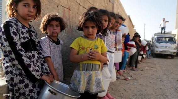 Syrian children wait in line to collect a free Iftar meal in the northern city of Raqqa during the Muslim holy month of Ramadan on July 14, 2013. The new head of the Syrian National Coalition Ahmad Jarba has backed calls for a truce from UN chief Ban Ki-Moon during the holy month of Ramadan. During Ramadan, Muslims the world over gather with family over festive meals after sunset when they can break the dawn-to-dusk fast. AFP PHOTO/MEZAR MATAR        (Photo credit should read MEZAR MATAR/AFP/Getty Images)