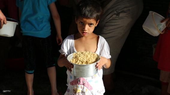 A Syrian boy carries a food ration distributed by volunteers to poor families during the Muslim holy fasting month of Ramadan, in a rebel-held area in the northern city of Aleppo on July 5, 2014. More than 162,000 people have been killed in Syria since the uprising against Assad's rule erupted in March 2011. AFP PHOTO/BARAA AL-HALABI        (Photo credit should read BARAA AL-HALABI/AFP/Getty Images)