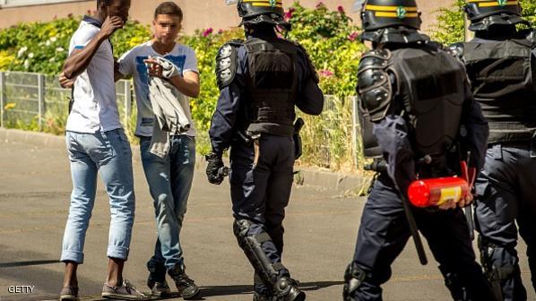 Young residents (L) face riot policemen (CRS) patrolling the La Bourgogne neighborhood, in Tourcoing, northern France, on June 4, 2015, after a third night of violence which led to twenty arrests. Violences started on June 1, 2015 at night after a driver, who was trying to escape from a police control, crashed into a tree.  AFP PHOTO / PHILIPPE HUGUEN        (Photo credit should read PHILIPPE HUGUEN/AFP/Getty Images)