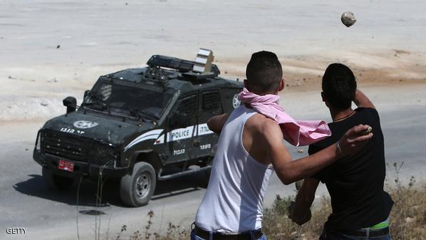 Palestinian protesters throw stones towards an Israeli security forces vehicle during clashes outside the compound of the Israeli Ofer Military Prison, near the West Bank town of Betunia, following a demonstration against Palestinian land confiscation and settlement expansion, on June 12, 2015. AFP PHOTO / ABBAS MOMANI        (Photo credit should read ABBAS MOMANI/AFP/Getty Images)