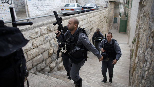 Israeli police officers patrol near a house purchased by Jews (back, with mural on the wall) in the mostly Arab neighbourhood of Silwan in east Jerusalem October 20, 2014. Israeli guards quietly occupied two purchased residential buildings in the Palestinian district of East Jerusalem on Monday, expanding a Jewish settler project in defiance of U.S. criticism. REUTERS/Ronen Zvulun (JERUSALEM - Tags: POLITICS REAL ESTATE)