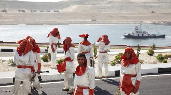 Musicians in pharonic dress stand beside a section of the New Suez Canal, operated by the Suez Canal Authority, during preparations for the official opening ceremony in Ismailia, Egypt, on Wednesday, Aug. 5, 2015. The expansion will meet future demand, with traffic expected to double to 97 vessels a day by 2023, said Mohab Mameesh, head of the Suez Canal Authority. Photographer: Shawn Baldwin/Bloomberg via Getty Images