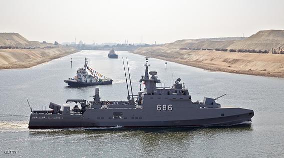 A military vessel makes its way through a section of the New Suez Canal, operated by the Suez Canal Authority, as a vessel travels along an older section of the Suez Canal, top, in Ismailia, Egypt, on Wednesday, Aug. 5, 2015. The expansion will meet future demand, with traffic expected to double to 97 vessels a day by 2023, said Mohab Mameesh, head of the Suez Canal Authority. Photographer: Shawn Baldwin/Bloomberg via Getty Images