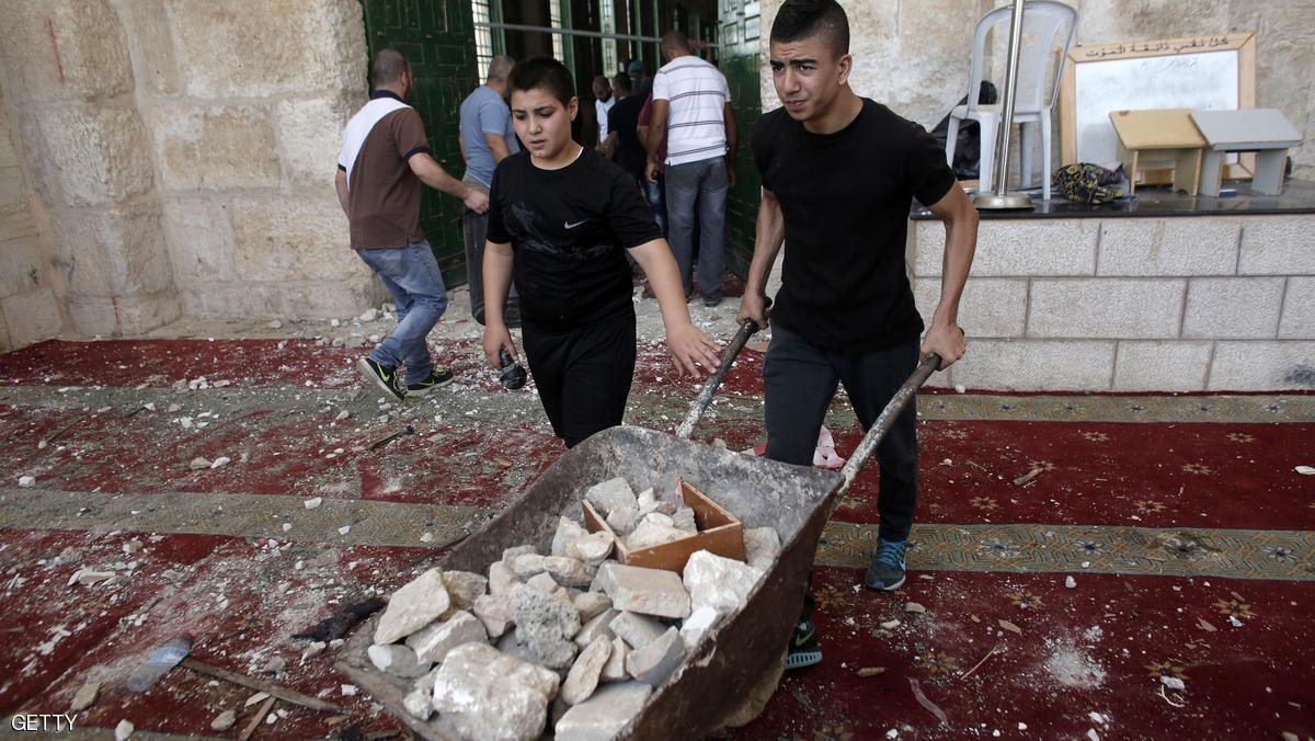 Palestinians clean up debris inside Al-Aqsa mosque in Jerusalem's Old City after clashes at the compound between Palestinians and Israeli police on September 13, 2015, just hours before the start of the Jewish New Year. The disturbances came with tensions running high after Israeli Defence Minister Moshe Yaalon last week outlawed the Murabitat (for females) and Murabitun groups which are made up of east Jerusalem Palestinians and Israeli Arabs and who confront Jewish visitors to the volatile Al-Aqsa mosque complex, considered Islam's third holiest shrine. AFP PHOTO / AHMAD GHARABLI (Photo credit should read AHMAD GHARABLI/AFP/Getty Images)