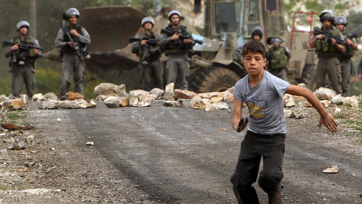 A Palestinian protester runs away from Israeli border guards during clashes following a protest against the expropriation of Palestinian land by Israel on March 8, 2013, in the village of Kafr Qaddum, near the occupied West Bank city of Nablus. AFP PHOTO/JAAFAR ASHTIYEH        (Photo credit should read JAAFAR ASHTIYEH/AFP/Getty Images)
