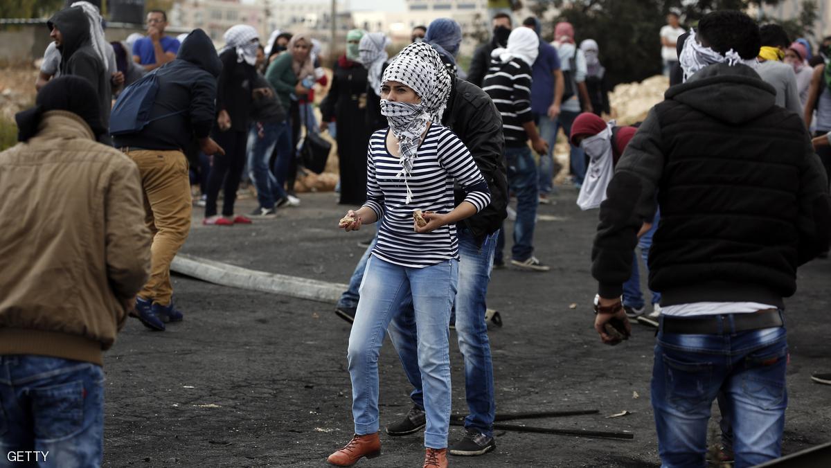 A Palestinian young woman from the Birzeit University holds stones during clashes with Israeli security forces in Beit El, on the outskirts of the West Bank city of Ramallah, on October 7, 2015. New violence rocked Israel and the Israeli-occupied West Bank, including a stabbing in annexed east Jerusalem, even as Israel and Palestinian president Mahmud Abbas took steps to ease tensions. AFP PHOTO / ABBAS MOMANI (Photo credit should read ABBAS MOMANI/AFP/Getty Images)