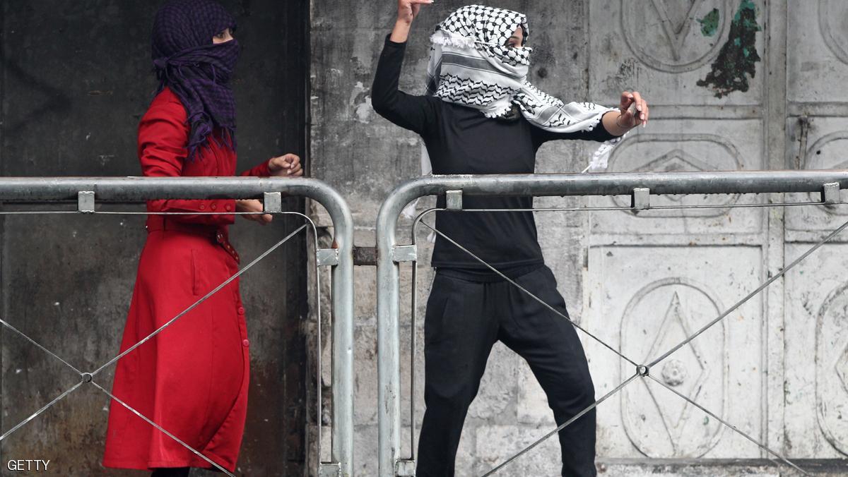 A Palestinian young woman throws stones towards Israeli security forces during clashes in the West Bank town of Hebron on October 7, 2015. New violence rocked Israel and the Israeli occupied West Bank, including an incident in which men thought to be undercover Israeli police opened fire on Palestinian stone throwers they had infiltrated, wounding three of them. AFP PHOTO / HAZEM BADER (Photo credit should read HAZEM BADER/AFP/Getty Images)