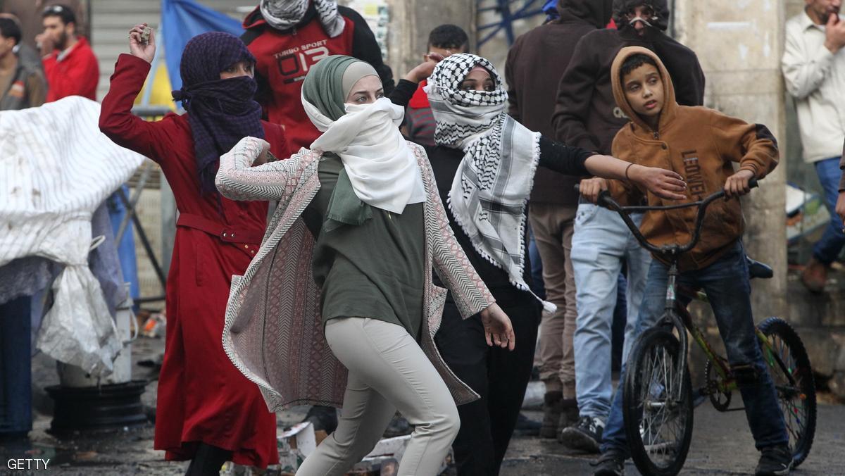 Palestinian young women throw stones towards Israeli security forces during clashes in the West Bank town of Hebron on October 7, 2015. New violence rocked Israel and the Israeli occupied West Bank, including an incident in which men thought to be undercover Israeli police opened fire on Palestinian stone throwers they had infiltrated, wounding three of them. AFP PHOTO / HAZEM BADER (Photo credit should read HAZEM BADER/AFP/Getty Images)