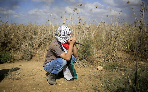 TOPSHOTS A Palestinian protester, holding a knife, looks on during clashes with Israeli security forces near the border fence between Israel and the Gaza Strip on October 9, 2015 east of Gaza City. A week of violence between Israelis and Palestinians spread to the Gaza Strip, with Israeli troops killing five people in clashes on the border and Islamist movement Hamas calling for more unrest. AFP PHOTO / MOHAMMED ABEDMOHAMMED ABED/AFP/Getty Images