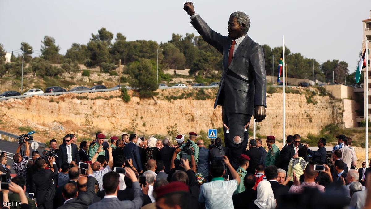 Palestinian and South African officials stand next to a giant statue of Nelson Mandela during its inauguration ceremony in the West Bank city of Ramallah on April 26, 2016. Palestinians inaugurated the statue of Mandela donated by the South African city of Johannesburg to their political capital. The six-metre (20-foot) two-tonne bronze statue was a gift from Johannesburg with which Ramallah is twinned. / AFP / ABBAS MOMANI (Photo credit should read ABBAS MOMANI/AFP/Getty Images)