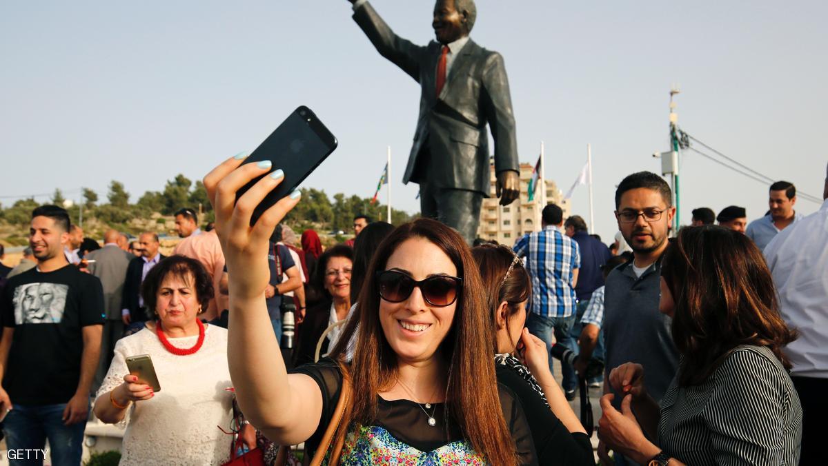 A Palestinian woman takes a selfie in front of a giant statue of Nelson Mandela following its inauguration ceremony in the West Bank city of Ramallah on April 26, 2016. Palestinians inaugurated the statue of Mandela donated by the South African city of Johannesburg to their political capital. The six-metre (20-foot) two-tonne bronze statue was a gift from Johannesburg with which Ramallah is twinned. / AFP / ABBAS MOMANI (Photo credit should read ABBAS MOMANI/AFP/Getty Images)