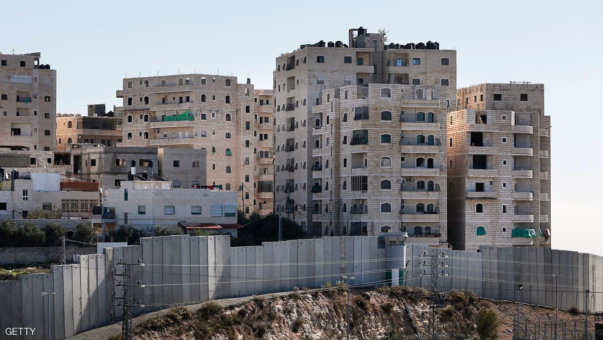 A partial view shows buildings in the Palestinian Shuafat refugee camp behind a section of Israel's controversial separation barrier in east Jerusalem on December 4, 2015. The Shuafat refugee camp, situated in east Jerusalem and home to tens of thousands of Palestinian, is entirely encolsed by Israel's controversial separation barrier and is cut off from the rest of the city. AFP PHOTO / THOMAS COEX / AFP / THOMAS COEX        (Photo credit should read THOMAS COEX/AFP/Getty Images)