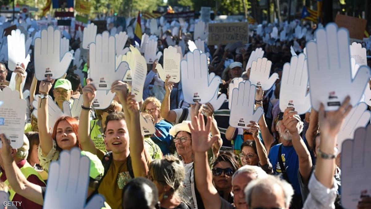 Protestors hold placards in the shape of hands during a demonstration in a Barcelona on June 19, 2016 under the slogan, "open borders, we welcome" in favour of rights for refugees and demanding that European authorities take action to secure safe passage routes for refugees.  / AFP / JOSEP LAGO        (Photo credit should read JOSEP LAGO/AFP/Getty Images)