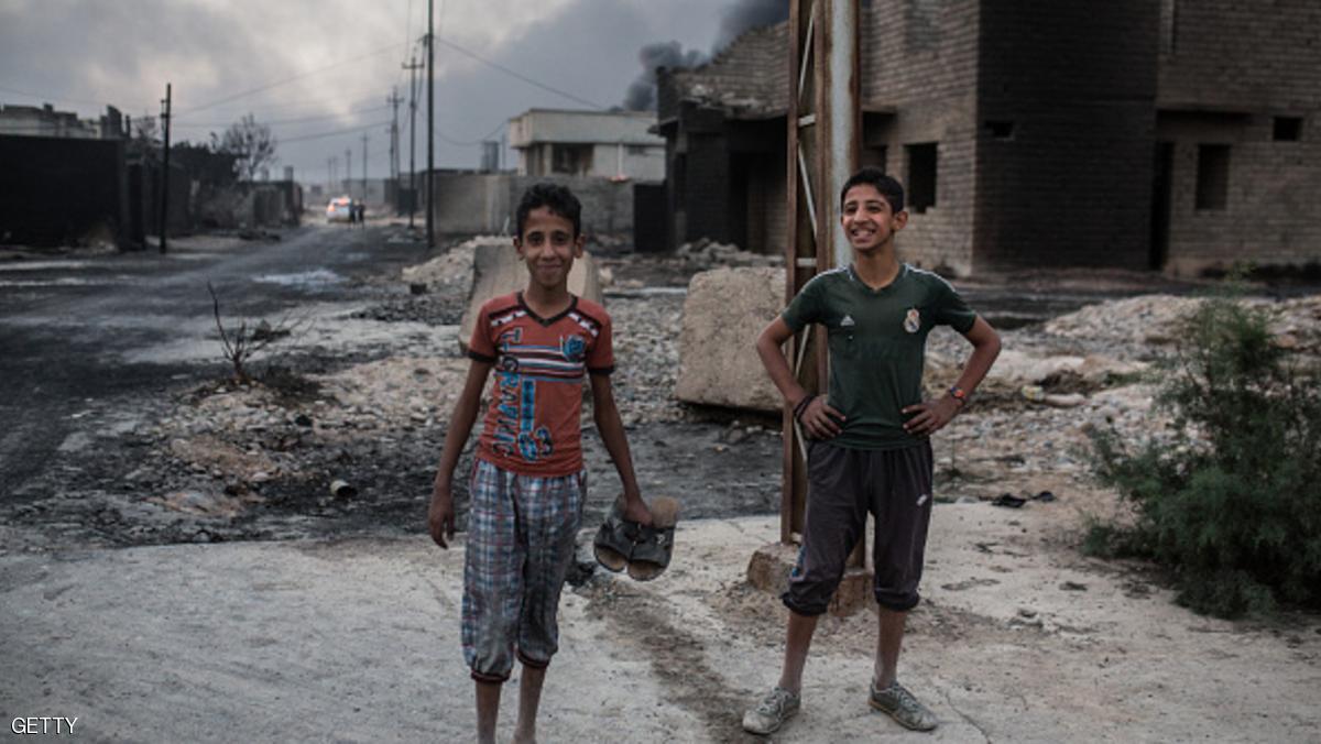 Iraqi children stand on a street as smoke billows from the Qayyarah area, some 60 kilometres (35 miles) south of Mosul, on October 19, 2016, during an operation by Iraqi forces against Islamic State (IS) group jihadists to retake the main hub city. In the biggest Iraqi military operation in years, forces have retaken dozens of villages, mostly south and east of Mosul, and are planning multiple assaults for October 20. / AFP / YASIN AKGUL        (Photo credit should read YASIN AKGUL/AFP/Getty Images)