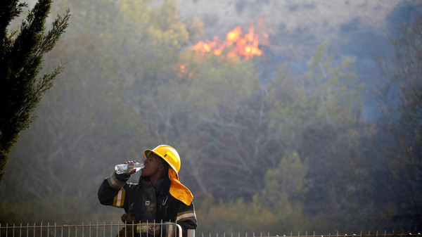 A firefighter drinks water as a wildfire burns in the northern city of Haifa, Israel November 24, 2016. REUTERS/Baz Ratner