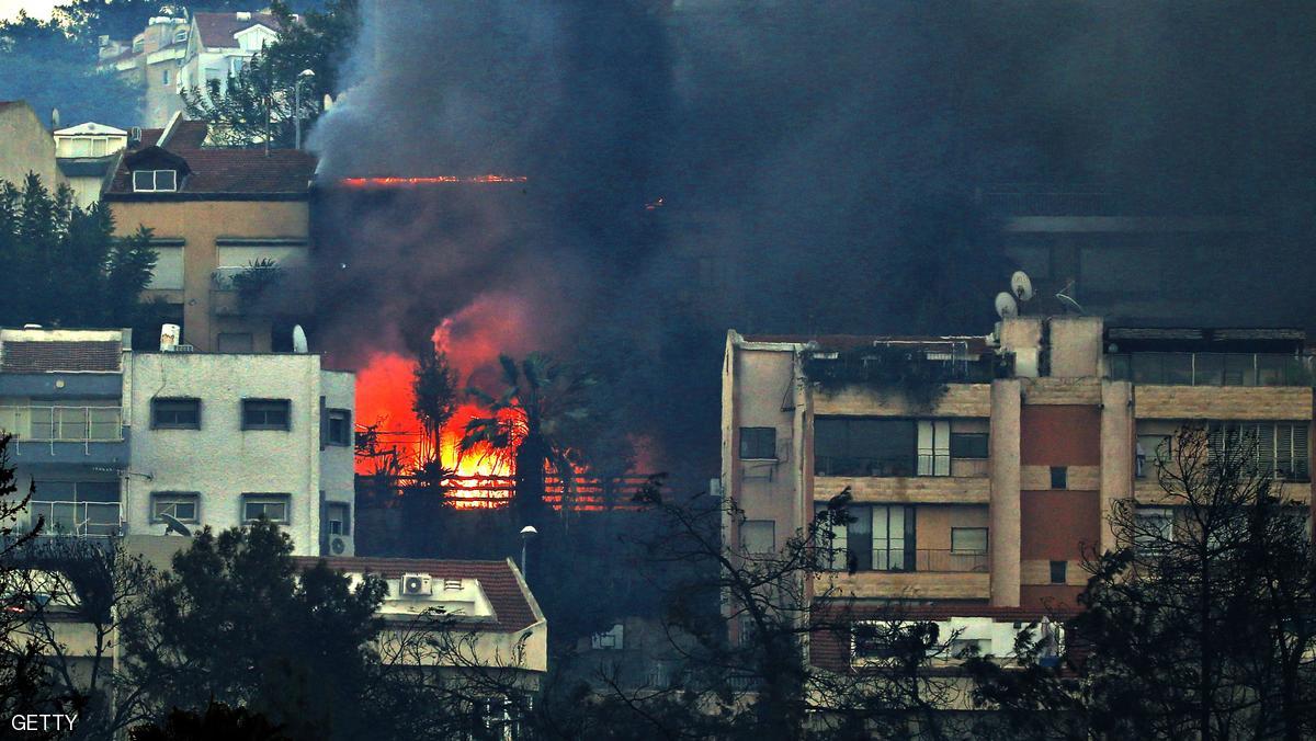 Smoke billows from a house as a fire rages in the northern Israeli port city of Haifa on November 24, 2016. Hundreds of Israelis fled their homes on the outskirts of the country's third city Haifa with others trapped inside as firefighters struggled to control raging bushfires, officials said. / AFP / AHMAD GHARABLI (Photo credit should read AHMAD GHARABLI/AFP/Getty Images)