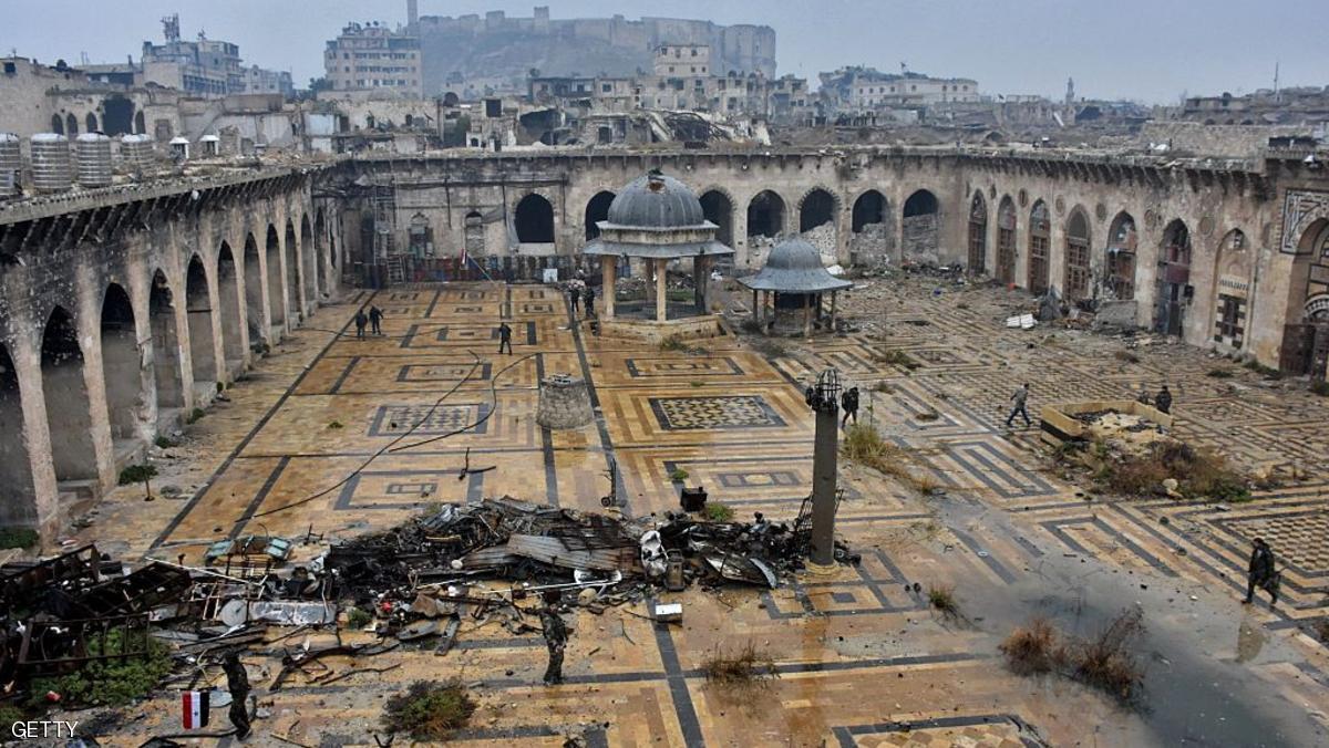 A general view shows Syrian pro-government forces walking in the ancient Umayyad mosque in the old city of Aleppo in the foreground and the city's citadel in the background on December 13, 2016, after they captured the area. After weeks of heavy fighting, regime forces were poised to take full control of Aleppo, dealing the biggest blow to Syria's rebellion in more than five years of civil war. / AFP / George OURFALIAN (Photo credit should read GEORGE OURFALIAN/AFP/Getty Images)