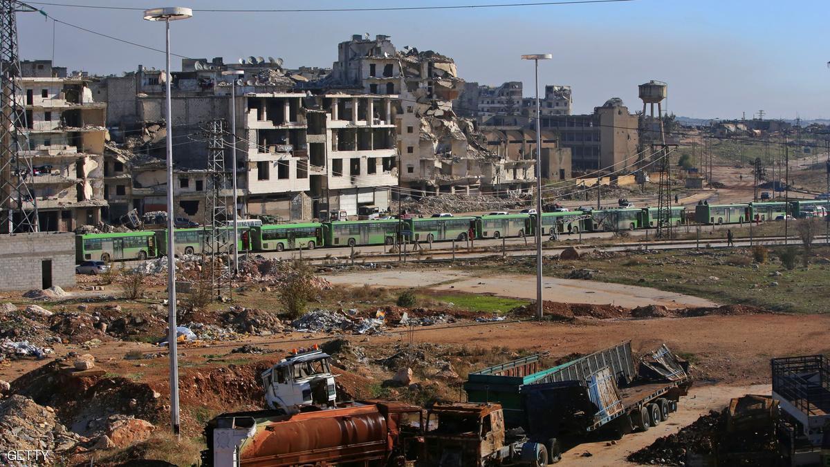Buses which will be used to evacuate rebel fighters and their families from rebel-held areas of Aleppo are seen waiting on December 15, 2016. Russia, Syrian military sources and rebel officials confirmed that a new agreement had been reached after a first evacuation plan collapsed the day before amid fresh fighting. Syrian state television reported that some 4,000 rebels and their families were to be evacuated. / AFP / Youssef KARWASHAN (Photo credit should read YOUSSEF KARWASHAN/AFP/Getty Images)