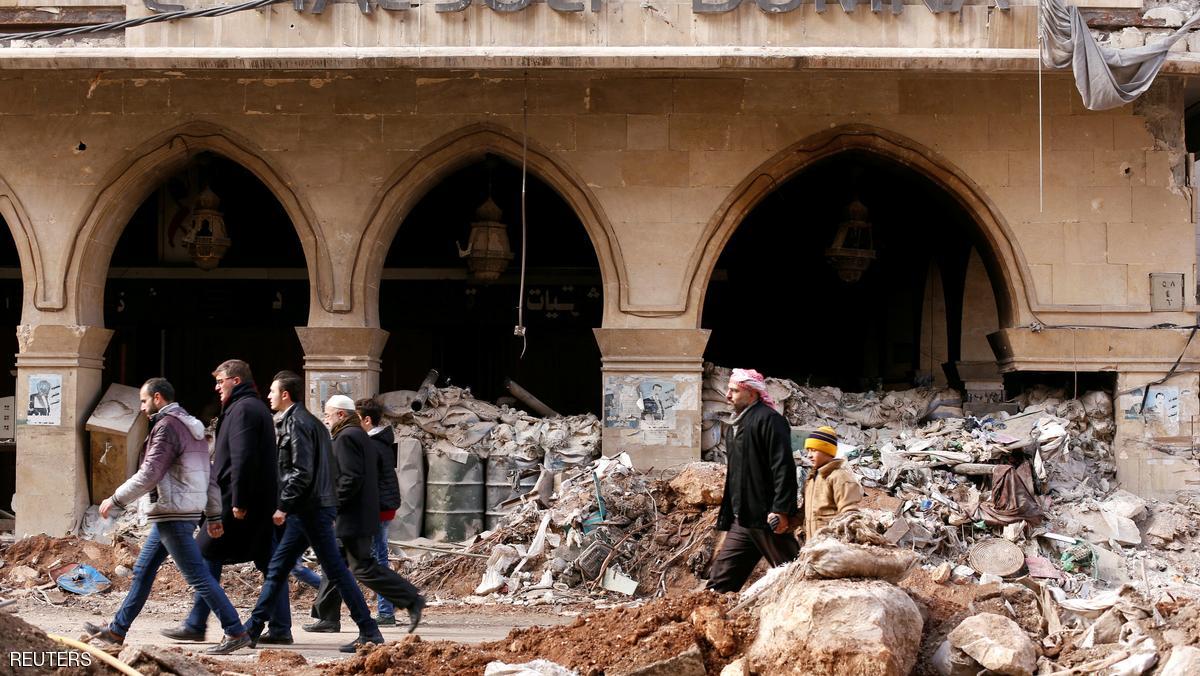 People walk past the damaged Coral Julia Dumna Hotel in the government controlled Old City of Aleppo, Syria December 17, 2016. REUTERS/ Omar Sanadiki