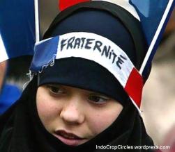 Seorang muslimah Perancis menggunakan ikat kepala bertuliskan "fraternité" yang berarti "brotherhood" atau "persaudaraan"