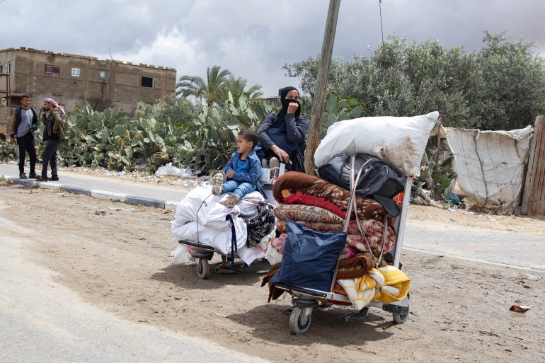 epa11321291 An Internally displaced Palestinian woman and child with their belongings at a street after an evacuation order issued by the Israeli army, in Rafah, southern Gaza Strip, 06 May 2024. The Israeli military stated on 06 May that the IDF has called on the residents of eastern Rafah to 'temporarily' evacuate to an expanded humanitarian area. The statement came ahead of an expected Israeli offensive on the city. More than 34,600 Palestinians and over 1,455 Israelis have been killed, according to the Palestinian Health Ministry and the Israel Defense Forces (IDF), since Hamas militants launched an attack against Israel from the Gaza Strip on 07 October 2023, and the Israeli operations in Gaza and the West Bank which followed it. EPA-EFE/HAITHAM IMAD